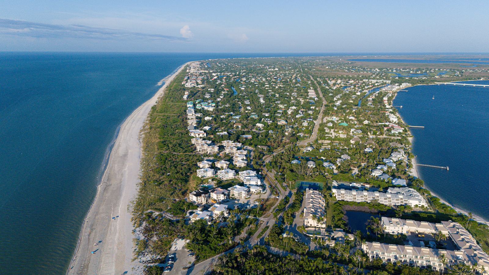 Aerial view of a low-rise Florida Gulf coast barrier island community, sand beach and turquoise water